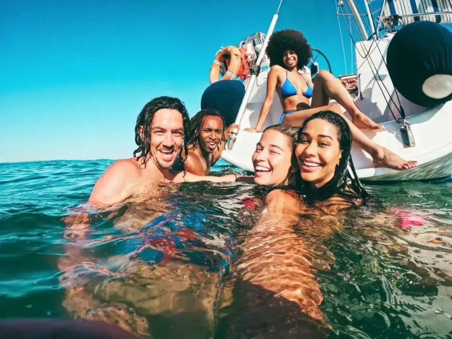 Friends taking an afternoon swim beside a boat